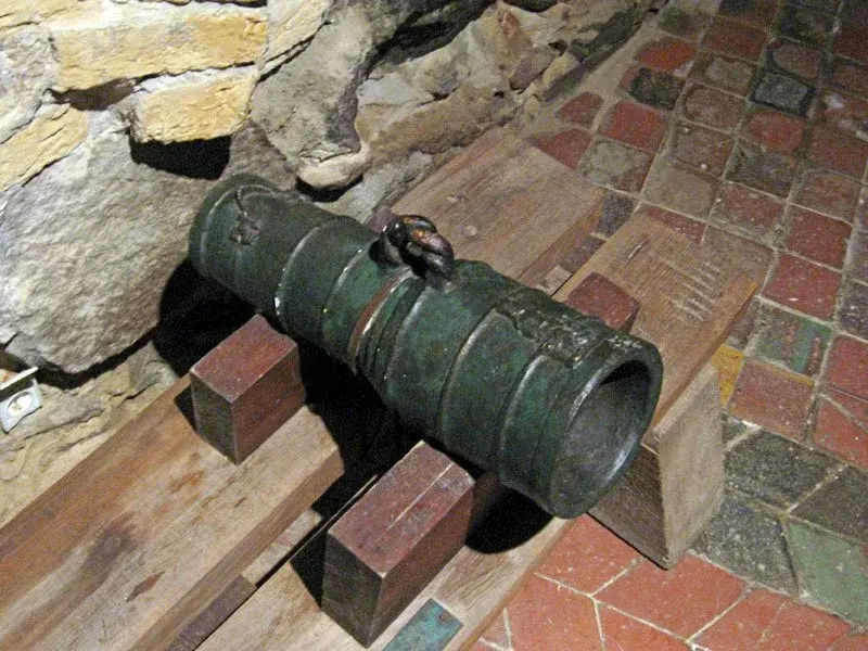 Eine kurze bronzene Bombarde des frühen 15. Jahrhunderts liegt auf einer hölzernen Unterlage