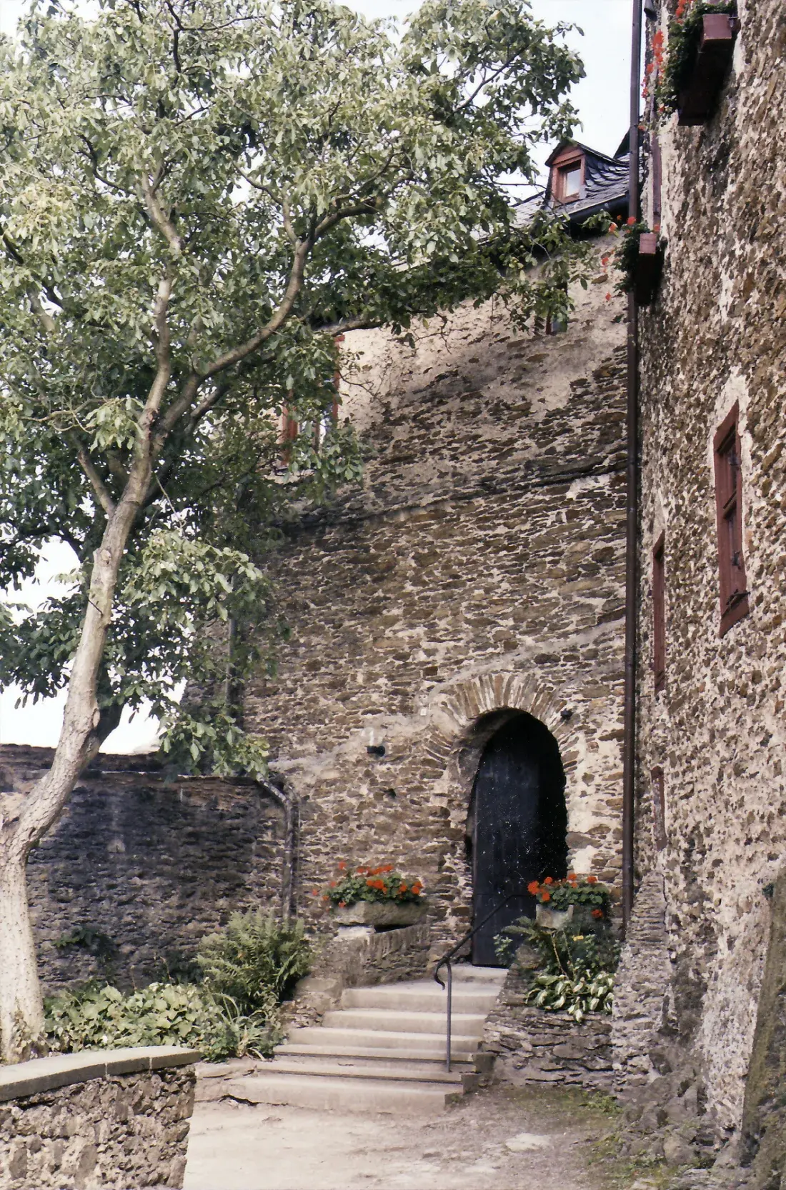 Ein enger, begrünter Innenhof der Marksburg zwischen hohen Steinbauten