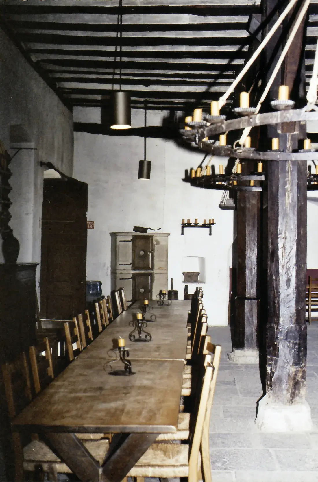 Ein heute eingerichteter Raum der Marksburg mit langem Holztisch, Herd, Stühlen und Kerzenleuchter