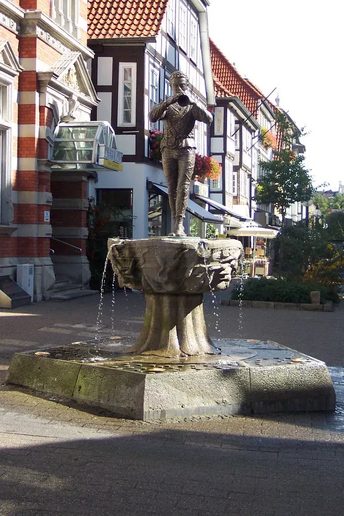 Rattenfängerbrunnen mit einer bronzenen Figur eines flötenspielenden Mannes in der Hamelner Altstadt