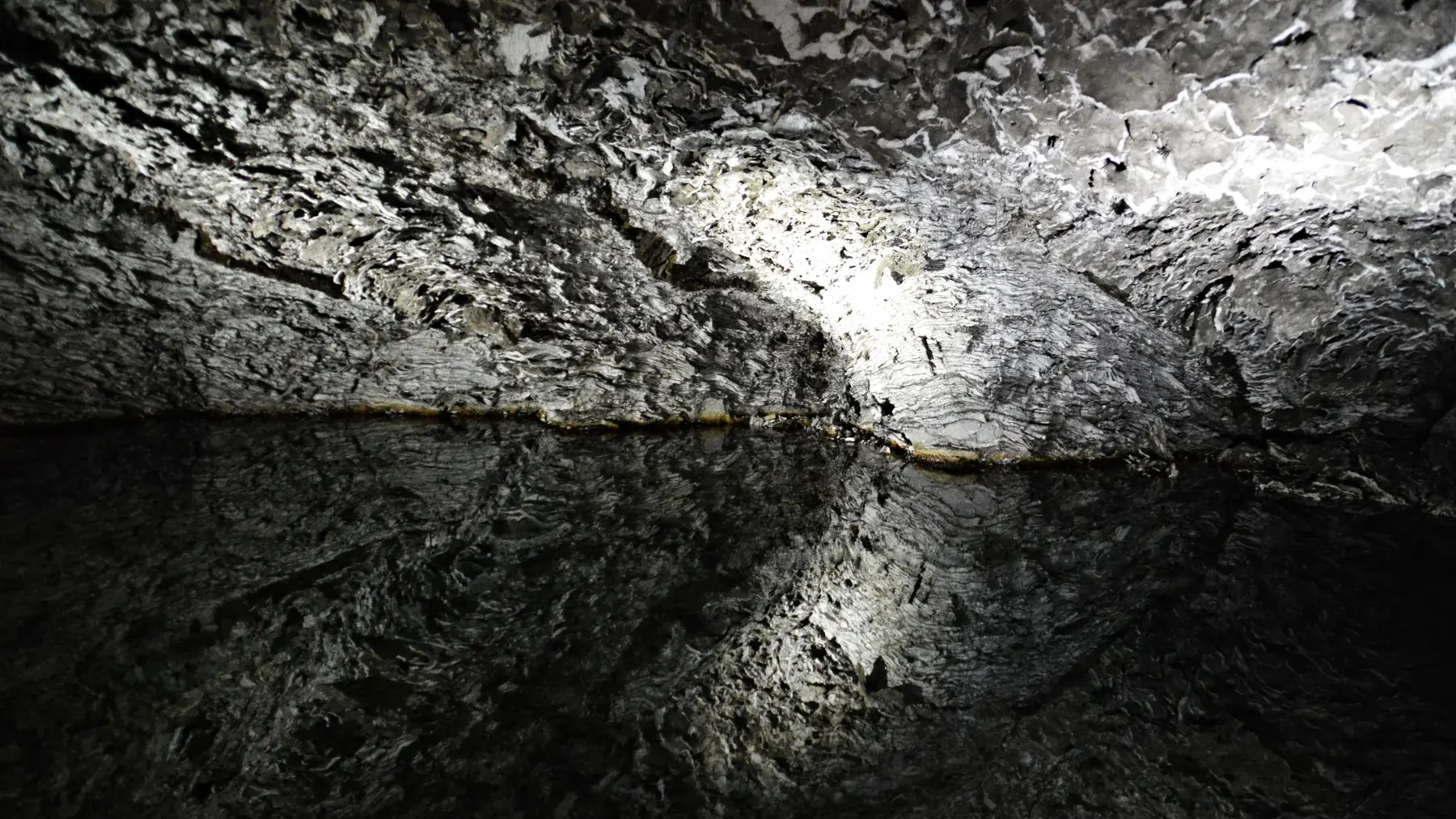 Weite unterirdische Halle der Barbarossahöhle mit geschichteten Anhydritdecken und einem Wasserbecken