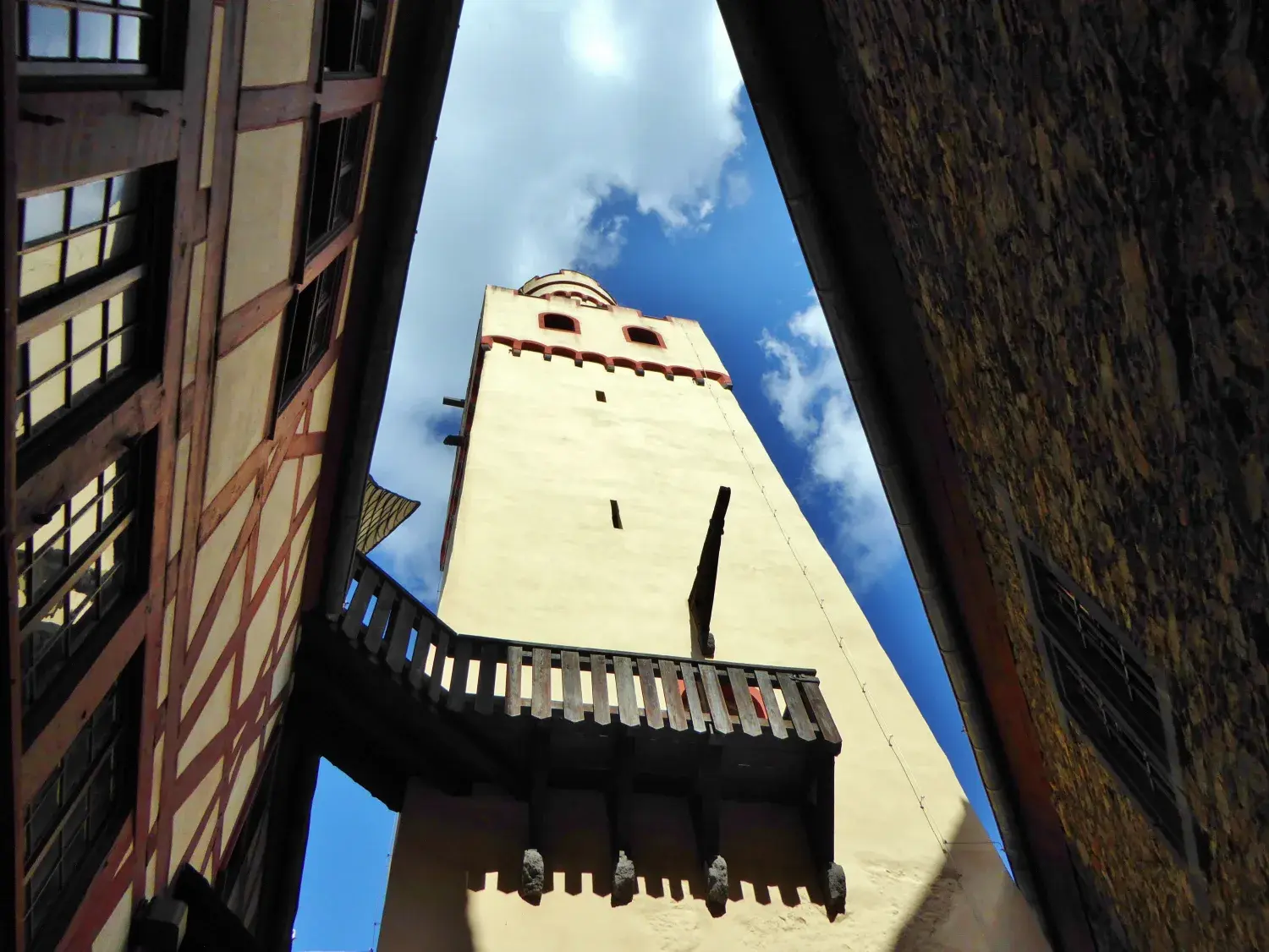Der hohe quadratische Bergfried der Marksburg zwischen dicht stehenden Burggebäuden